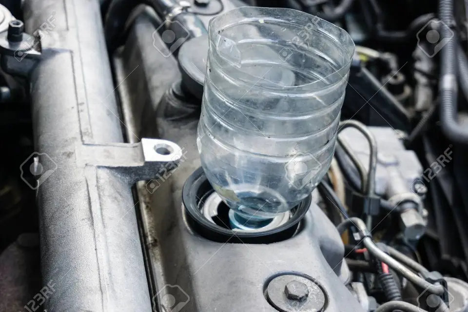 82426083-changing-oil-in-car-using-old-plastic-bottle-as-a-funnel.jpg